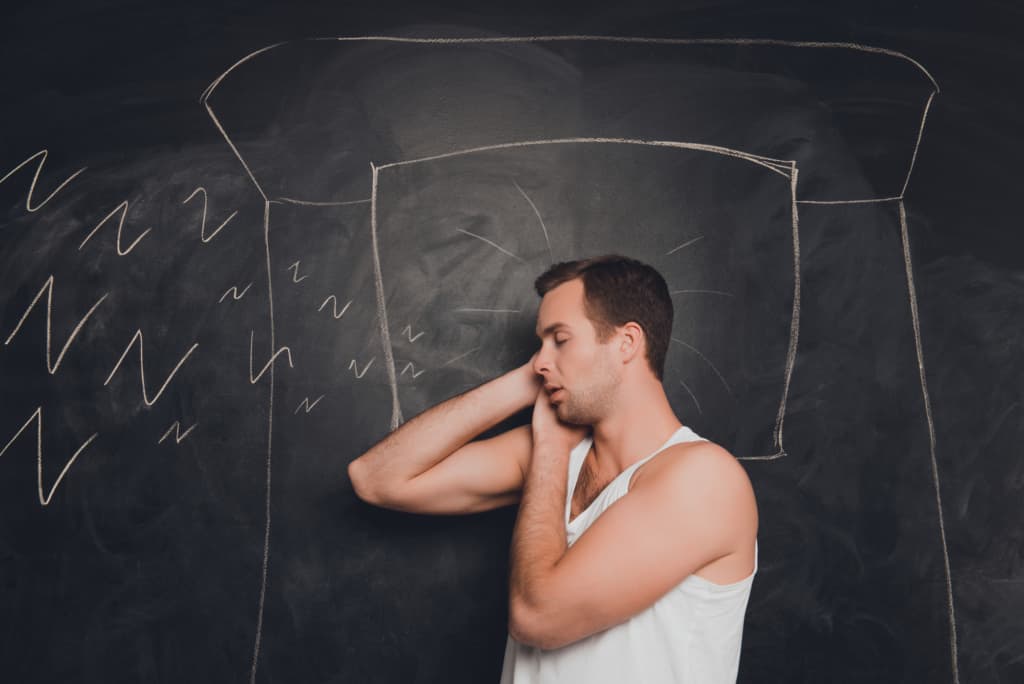 Young man against the background of chalkboard sleeping and snoring